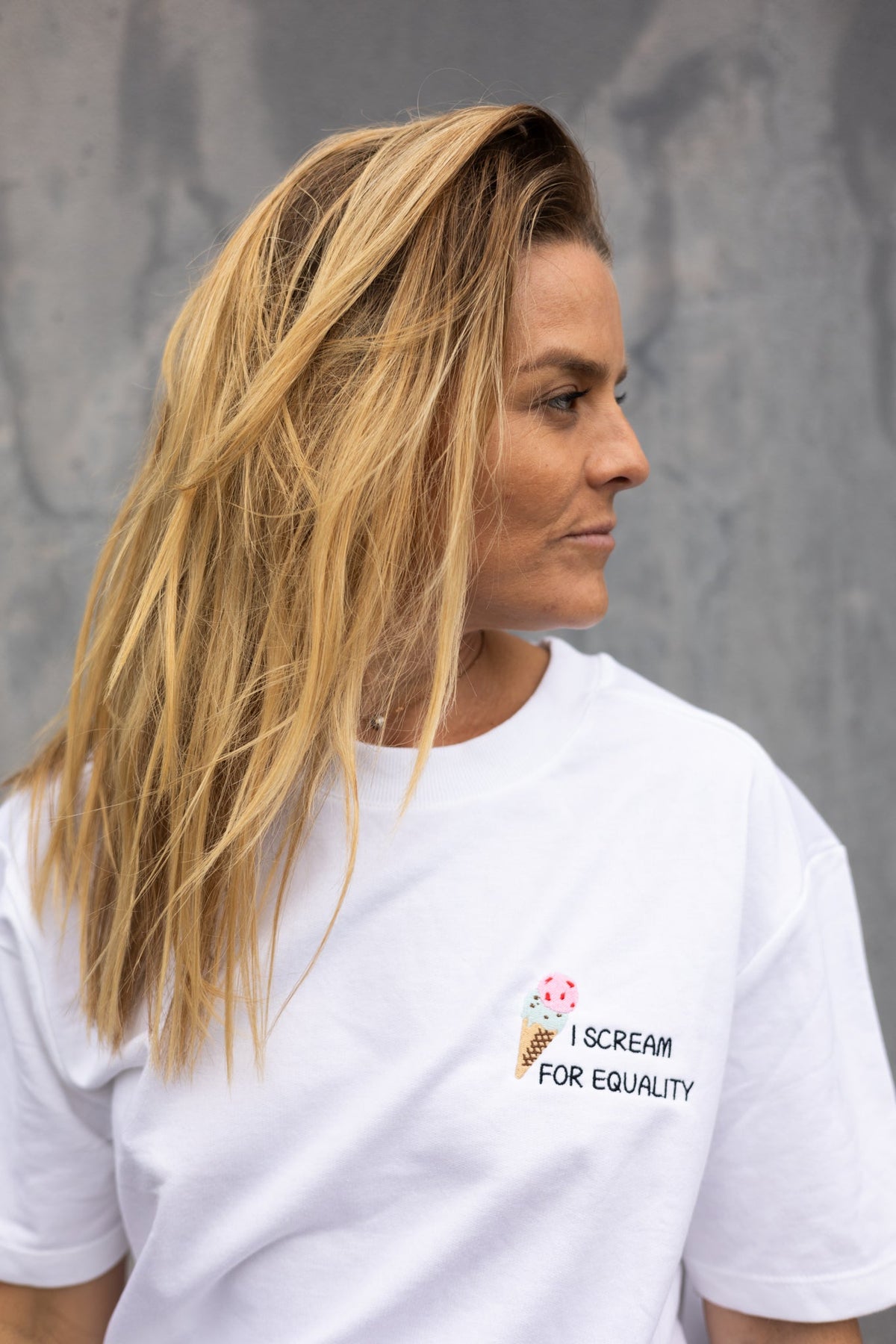Side view of the white I Scream for Equality tee with the ice cream cone embroidery
