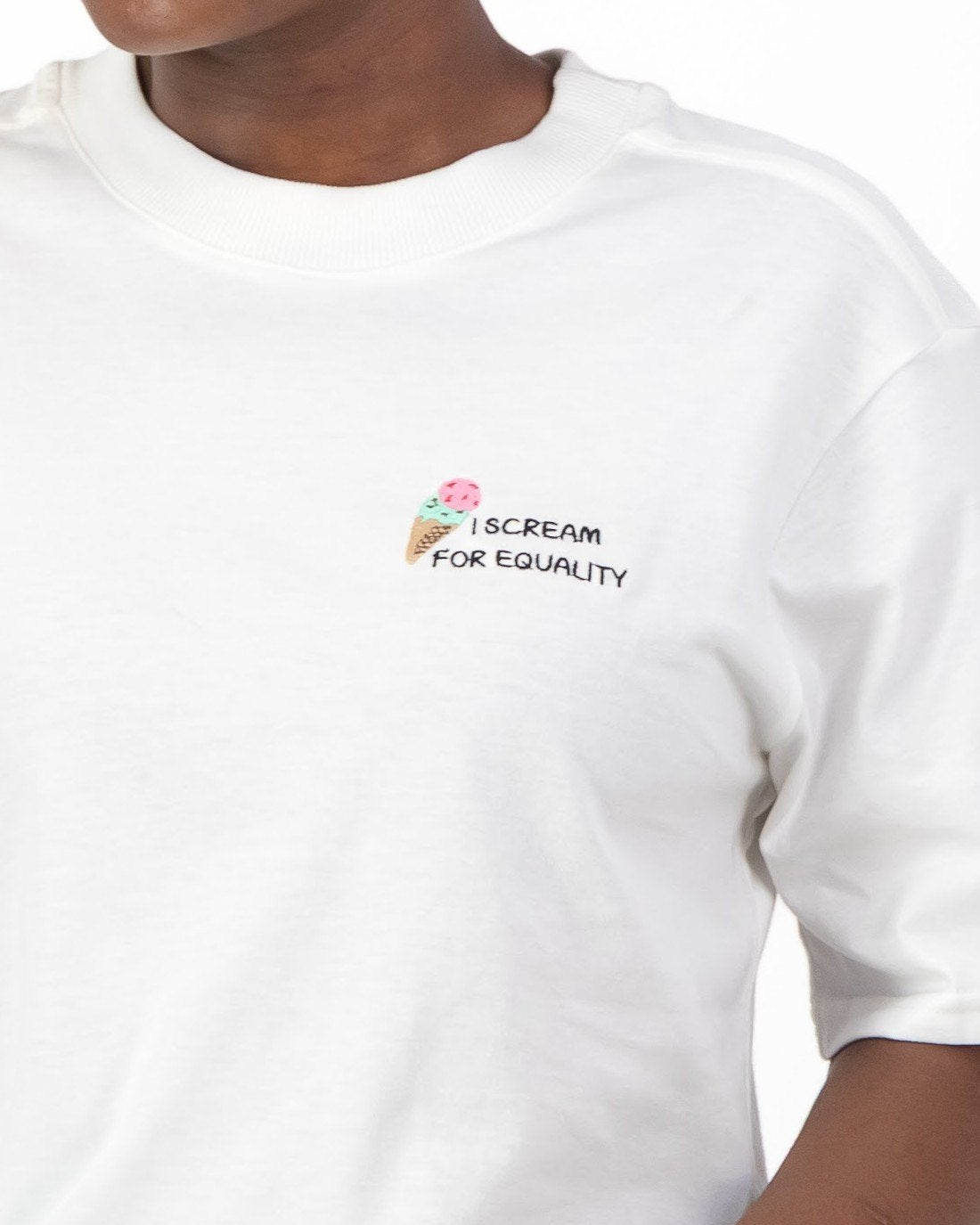 Close up of the ice cream cone embroidery and I Scream for Equality slogan on the white tee