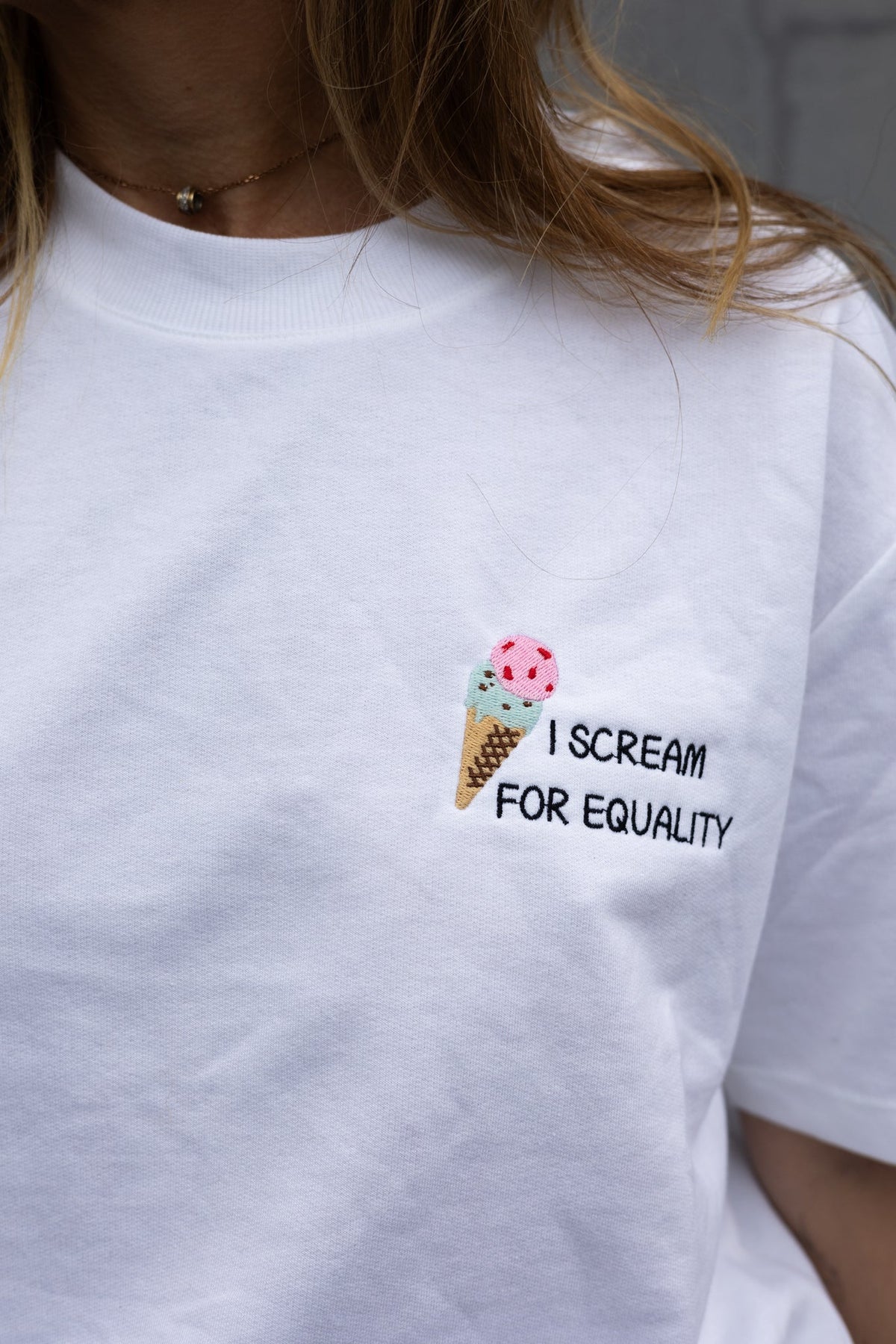 Close up of the pink and mint ice cream cone embroidery reading I Scream for Equality
