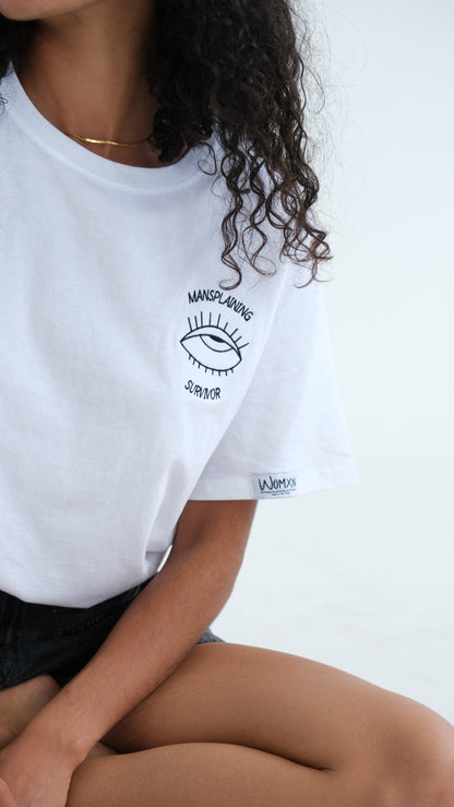 Close up of the Mansplaining Survivor eye embroidery on the white tee
