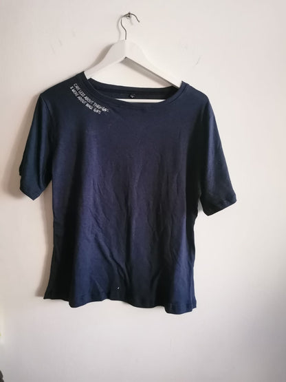 The navy Care Less About Thigh Gaps and More About Wage Gaps tee on a hanger, slogan in white along the collar
