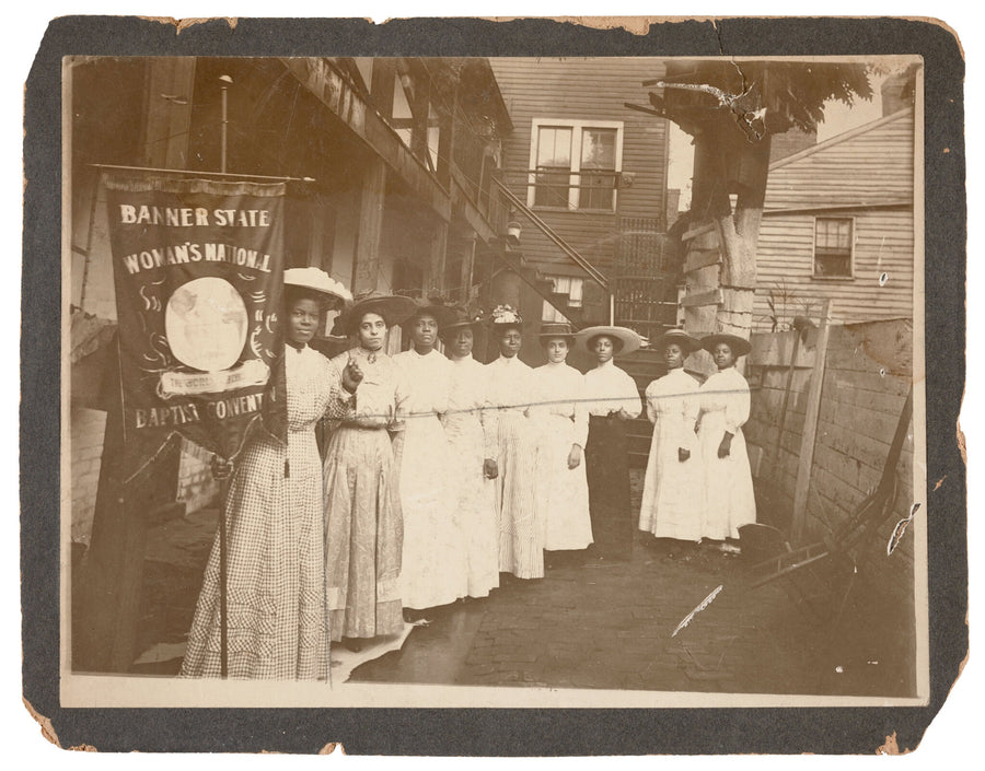 Nannie Helen Burroughs holding a Woman's National Baptist Convention banner, with eight other women, around 1910