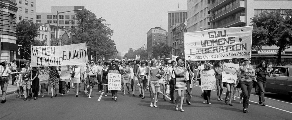 Women carrying banners reading Women Demand Equality and GWU Women's Liberation at the march in Washington, 26 August 1970