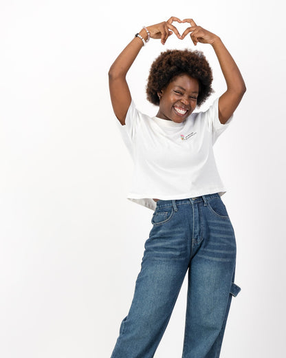 Woman making a heart shape with her hands above her head in the white I Scream for Equality tee