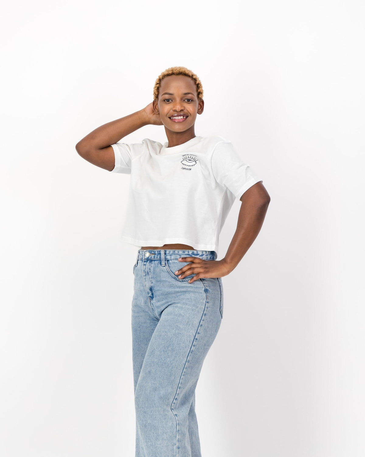 Woman with one hand in her hair wearing the white Mansplaining Survivor tee and jeans