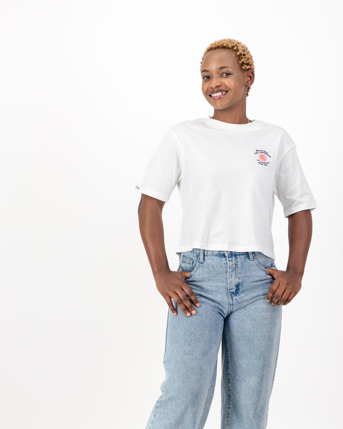 Woman wearing the white May You Have the Confidence of a Mediocre White Man tee with light blue jeans, front view