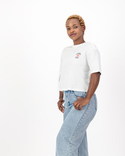 Three quarter view of the white May You Have the Confidence of a Mediocre White Man tee, boxy fit, worn with jeans