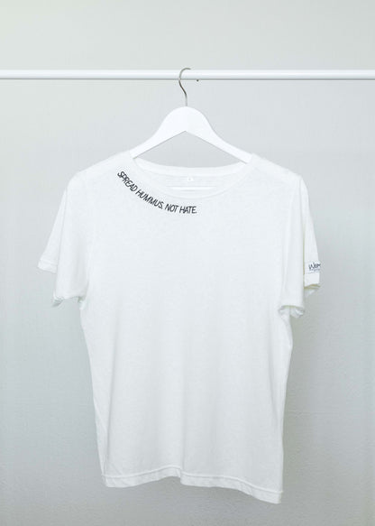 The white Spread Hummus Not Hate tee on a hanger